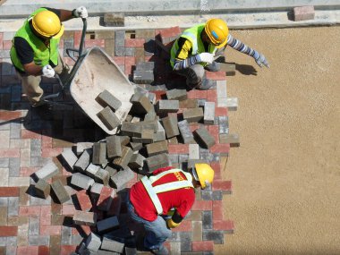 MALACCA, MALAYSIA -MAC 08, 2017: İnşaat işçileri inşaat alanında yol için beton kaldırım taşları kuruyor ve düzenliyor. 