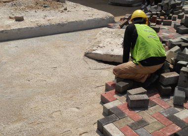 MALACCA, MALAYSIA -MAC 08, 2017: İnşaat işçileri inşaat alanında yol için beton kaldırım taşları kuruyor ve düzenliyor. 