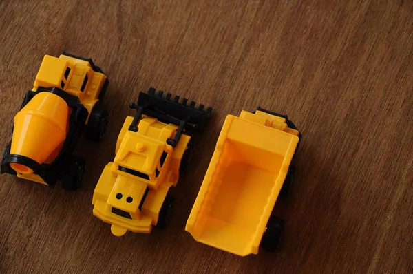 一组小型重型机械玩具 推土机和混凝土搅拌机 全部由塑料制成 在木制纹理背景上隔离 — 图库照片