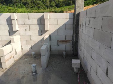 SEREMBAN, MALAYSIA - 19 Mart 2021: Otoklavize edilmiş beton blok veya inşaat alanında kullanılan AAC bloğu. Özel havan topu kullanan işçiler tarafından kurulur. Kolay ve hızlı.  