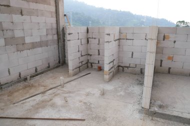 SEREMBAN, MALAYSIA - 19 Mart 2021: Otoklavize edilmiş beton blok veya inşaat alanında kullanılan AAC bloğu. Özel havan topu kullanan işçiler tarafından kurulur. Kolay ve hızlı.  