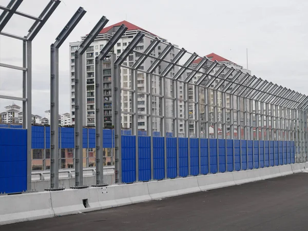 SELANGOR, MALAYSIA - JULY 5, 2020: Noise barriers are installed along the vehicle lane bordering the residence to prevent noise pollution to the surrounding locals.
