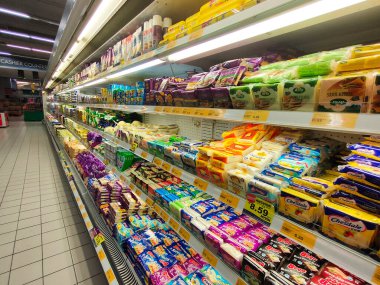 PenANG, MALAYSIA -JULY17, 2021: Hipermarketlerdeki satış raflarında çeşitli peynir ve tereyağı sergilenmektedir. Kan grubuna ve markasına göre sıralanmış. Müşterilerin işini kolaylaştırmak için fiyat etiketleri var..