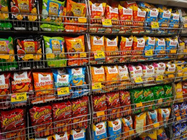 PENANG, MALAYSIA -APRIL 28, 2021: Seçici olarak markette raflarda bulunan çeşitli markalı abur cuburlar ve abur cuburlar üzerinde duruldu. Her birinin kendi fiyat etiketi var.. 