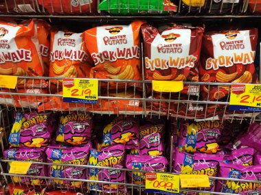 PENANG, MALAYSIA -APRIL 28, 2021: Seçici olarak markette raflarda bulunan çeşitli markalı abur cuburlar ve abur cuburlar üzerinde duruldu. Her birinin kendi fiyat etiketi var.. 