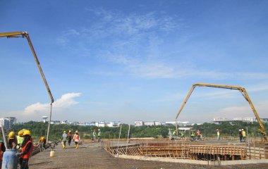 MALACCA, MALAYSIA -HAZİRAN 31, 2017: İnşaat işçileri inşaat sahasındaki beton pompalama makinesinin beton hortumunu kullanarak inşaat alanındaki döşeme kaplamasına döküyorlar.  
