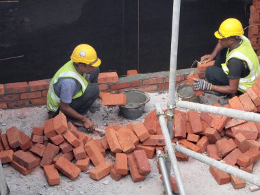 JOHOR, MALAYSIA - Aralık 05, 2016: Tuğlacı inşaat sahasına duvar örmek için tuğla döşedi. 