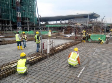 KUALA LUMPUR, MALAYSIA - 14 Mart 2017: İnşaat işçileri inşaat sahasına döşeme destek barı kurup üretiyorlar. Destek çubuğu küçük bir kabloyla birbirine bağlanmış.. 