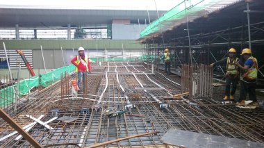 KUALA LUMPUR, MALAYSIA - 14 Mart 2017: İnşaat işçileri inşaat sahasına döşeme destek barı kurup üretiyorlar. Destek çubuğu küçük bir kabloyla birbirine bağlanmış.. 