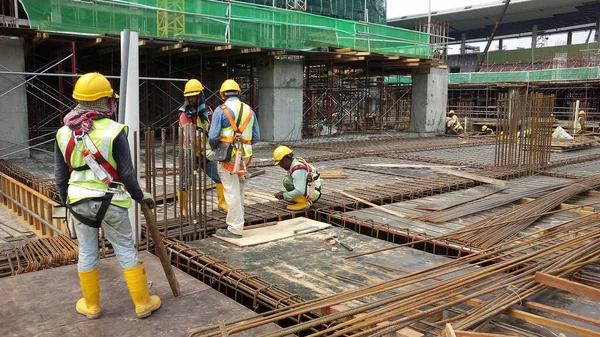 KUALA LUMPUR, MALAYSIA -14 HAZİRAN 2017: İnşaat işçileri inşaat alanında çelik takviye çubuğu üretiyorlar. Destek çubuğu küçük bir kabloyla birbirine bağlanmış..    