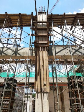 KUALA LUMPUR, MALAYSIA-SEPTEMBER 19, 2020: İnşaat alanındaki sütun kereste formu ve takviye barı. İnşaat işçileri tarafından kurulmuş. Yapı geçici ahşap desteği tarafından destekleniyor.