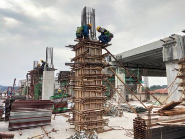 KUALA LUMPUR, MALAYSIA-SEPTEMBER 19, 2020: İnşaat alanındaki sütun kereste formu ve takviye barı. İnşaat işçileri tarafından kurulmuş. Yapı geçici ahşap desteği tarafından destekleniyor.