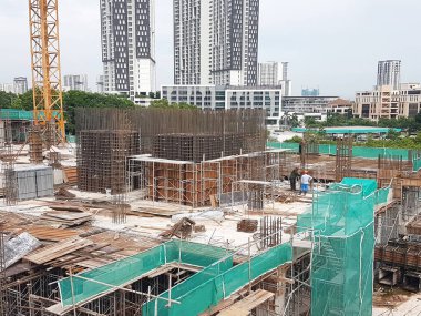 PENANG, MALAYSIA -16 Haziran 2021: İnşaat alanında yapısal çalışmalar devam ediyor. İnşaat işçileri metal ya da kerestelerden yapılmış bir form hazırlıyorlar. Güvenlik özellikleri çok önemli..
