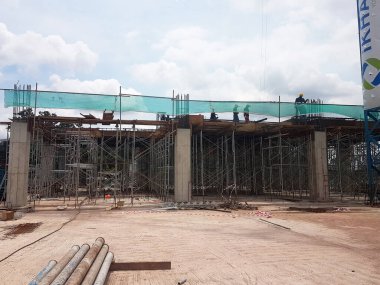 PENANG, MALAYSIA -16 Haziran 2021: İnşaat alanında yapısal çalışmalar devam ediyor. İnşaat işçileri metal ya da kerestelerden yapılmış bir form hazırlıyorlar. Güvenlik özellikleri çok önemli..