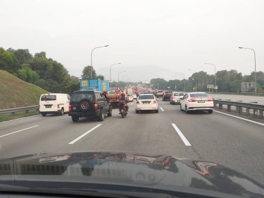KUALA LUMPUR, MALAYSIA - 3 Temmuz 2020: otoyolda trafik sıkışıklığı. Araçlar kendi şeritlerinde yavaş hareket ederler. Ters yönden gelen araçlar sorunsuzca hareket ediyor.