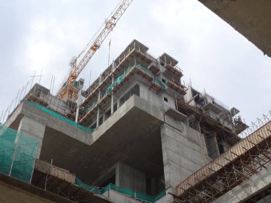 PENANG, MALAYSIA -18 Haziran 2021: İnşaat alanında yapısal çalışmalar devam ediyor. İnşaat işçileri metal ya da kerestelerden yapılmış bir form hazırlıyorlar. Güvenlik özellikleri çok önemli..