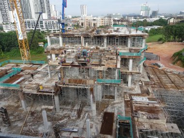 PENANG, MALAYSIA -18 Haziran 2021: İnşaat alanında yapısal çalışmalar devam ediyor. İnşaat işçileri metal ya da kerestelerden yapılmış bir form hazırlıyorlar. Güvenlik özellikleri çok önemli..