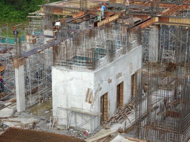 PENANG, MALAYSIA -18 Haziran 2021: İnşaat alanında yapısal çalışmalar devam ediyor. İnşaat işçileri metal ya da kerestelerden yapılmış bir form hazırlıyorlar. Güvenlik özellikleri çok önemli..