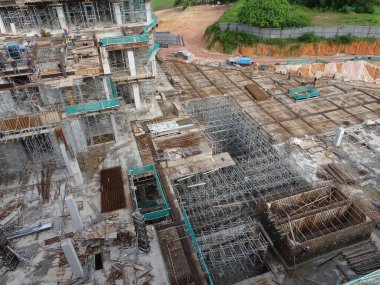 PENANG, MALAYSIA -18 Haziran 2021: İnşaat alanında yapısal çalışmalar devam ediyor. İnşaat işçileri metal ya da kerestelerden yapılmış bir form hazırlıyorlar. Güvenlik özellikleri çok önemli..