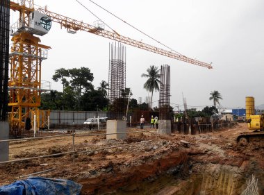 PENANG, MALAYSIA -18 Haziran 2021: İnşaat alanında yapısal çalışmalar devam ediyor. İnşaat işçileri metal ya da kerestelerden yapılmış bir form hazırlıyorlar. Güvenlik özellikleri çok önemli..