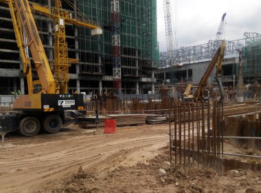 PENANG, MALAYSIA -18 Haziran 2021: İnşaat alanında yapısal çalışmalar devam ediyor. İnşaat işçileri metal ya da kerestelerden yapılmış bir form hazırlıyorlar. Güvenlik özellikleri çok önemli..