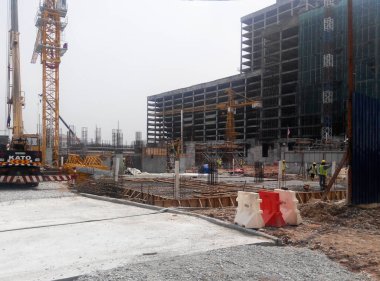 PENANG, MALAYSIA -18 Haziran 2021: İnşaat alanında yapısal çalışmalar devam ediyor. İnşaat işçileri metal ya da kerestelerden yapılmış bir form hazırlıyorlar. Güvenlik özellikleri çok önemli..