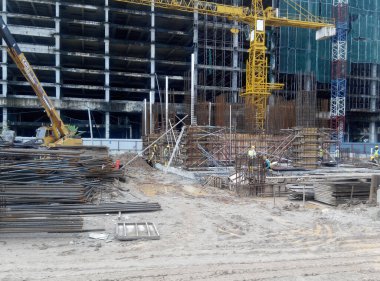 PENANG, MALAYSIA -18 Haziran 2021: İnşaat alanında yapısal çalışmalar devam ediyor. İnşaat işçileri metal ya da kerestelerden yapılmış bir form hazırlıyorlar. Güvenlik özellikleri çok önemli..