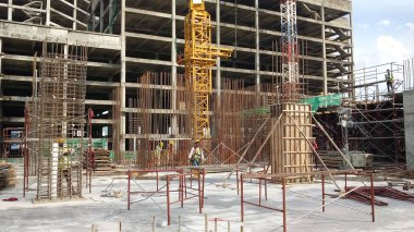 PENANG, MALAYSIA -18 Haziran 2021: İnşaat alanında yapısal çalışmalar devam ediyor. İnşaat işçileri metal ya da kerestelerden yapılmış bir form hazırlıyorlar. Güvenlik özellikleri çok önemli..