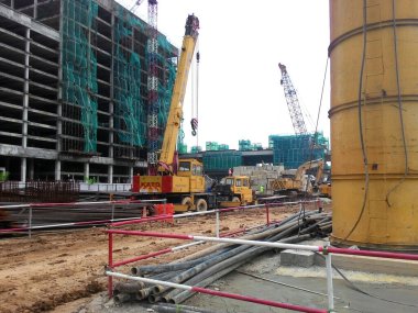 PENANG, MALAYSIA -18 Haziran 2021: İnşaat alanında yapısal çalışmalar devam ediyor. İnşaat işçileri metal ya da kerestelerden yapılmış bir form hazırlıyorlar. Güvenlik özellikleri çok önemli..