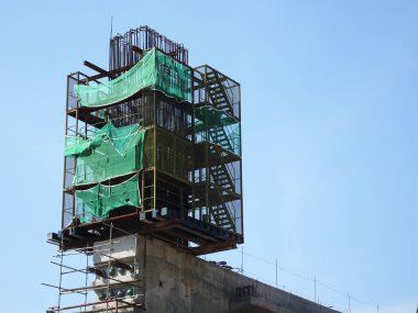 PENANG, MALAYSIA - 2 Temmuz 2021: mega altyapı yapısı yapım aşamasında. İnşaat işçileri sıkı güvenlik yönetmelikleriyle iş yapıyorlar. Yapılandırılan yapıyı desteklemek için geçici olarak kurulur.