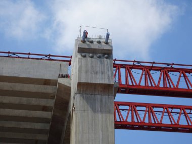 PENANG, MALAYSIA - 2 Temmuz 2021: mega altyapı yapısı yapım aşamasında. İnşaat işçileri sıkı güvenlik yönetmelikleriyle iş yapıyorlar. Yapılandırılan yapıyı desteklemek için geçici olarak kurulur.