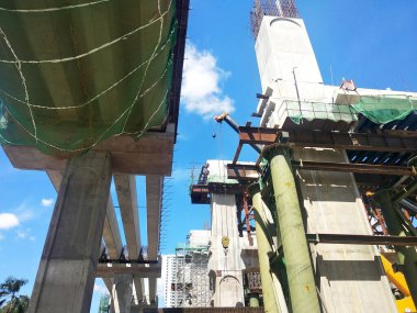 PENANG, MALAYSIA - 2 Temmuz 2021: mega altyapı yapısı yapım aşamasında. İnşaat işçileri sıkı güvenlik yönetmelikleriyle iş yapıyorlar. Yapılandırılan yapıyı desteklemek için geçici olarak kurulur.