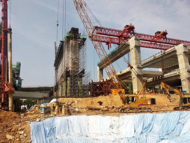 PENANG, MALAYSIA - 2 Temmuz 2021: mega altyapı yapısı yapım aşamasında. İnşaat işçileri sıkı güvenlik yönetmelikleriyle iş yapıyorlar. Yapılandırılan yapıyı desteklemek için geçici olarak kurulur.