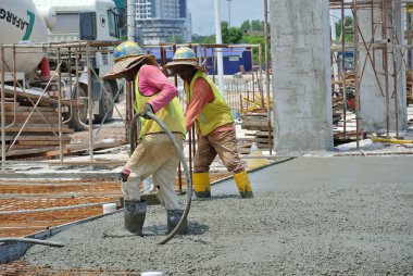 İnşaat İşçileri beton vibratör kullanarak