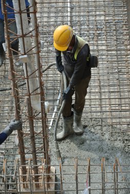 İnşaat İşçileri beton vibratör kullanarak