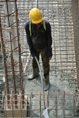 İnşaat İşçileri beton vibratör kullanarak