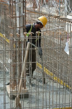 İnşaat İşçileri beton vibratör kullanarak