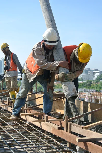 Construction Workers casting concrete using concrete hose — Stock Photo, Image