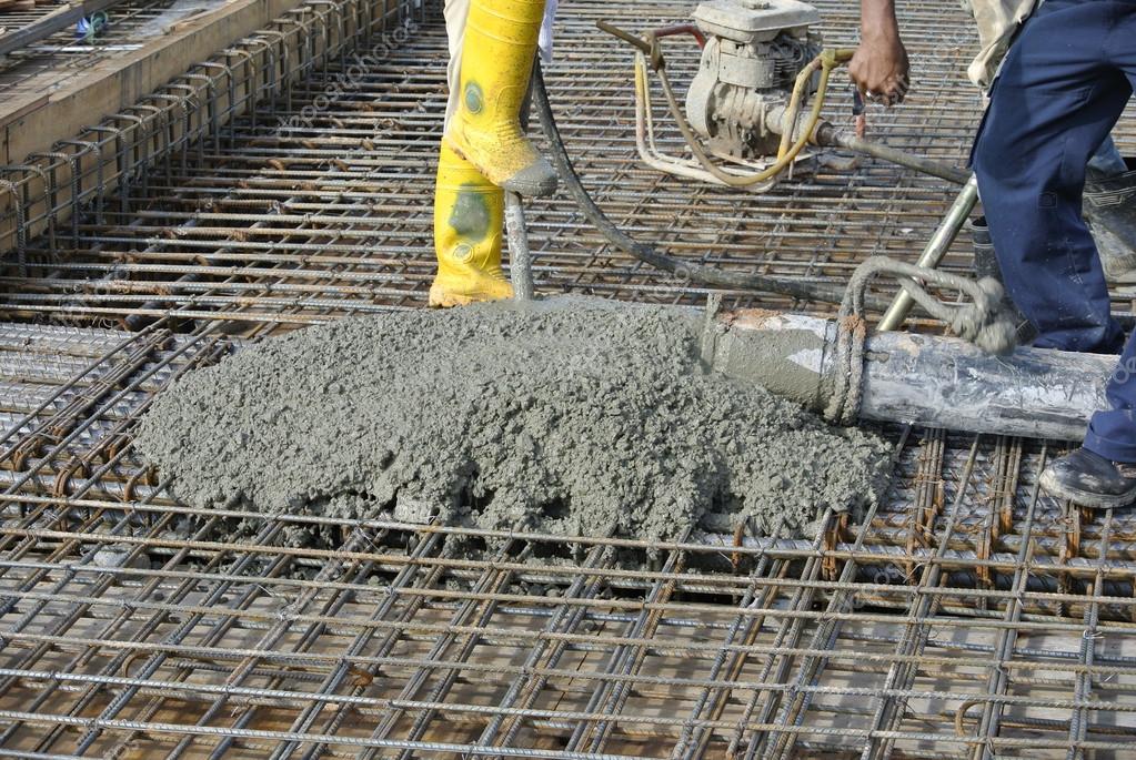 Construction Workers casting concrete using concrete hose Stock Photo