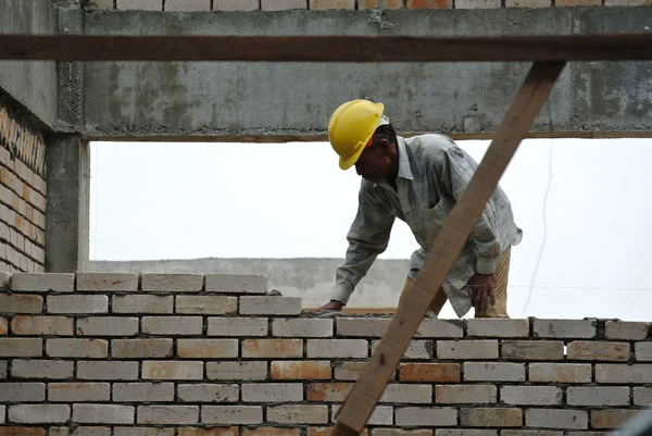 Pracowników budowlanych układanie cegły na budowie — Zdjęcie stockowe