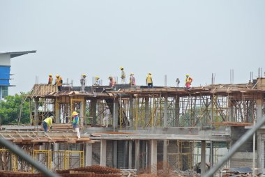 İnşaat işçileri şantiyede çalışıyor.