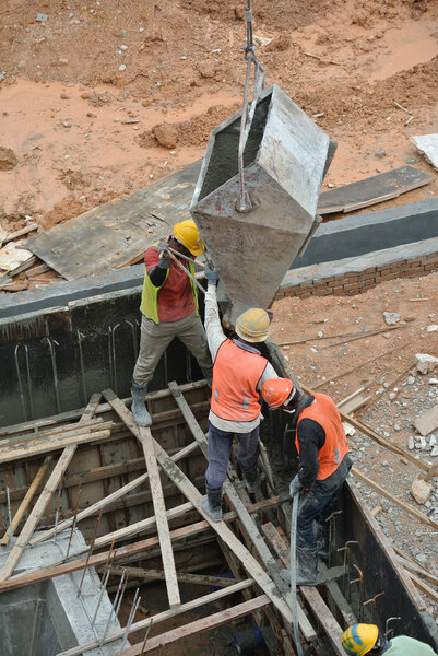 Group of construction workers casting reinforcement concrete wall