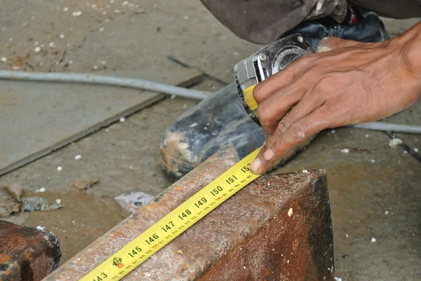 Pekerja menggunakan pengukur pita untuk mengukur baja ringan — Stok Foto