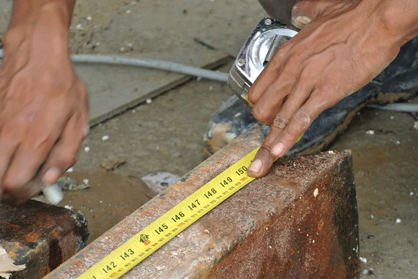 Pekerja menggunakan pengukur pita untuk mengukur baja ringan — Stok Foto