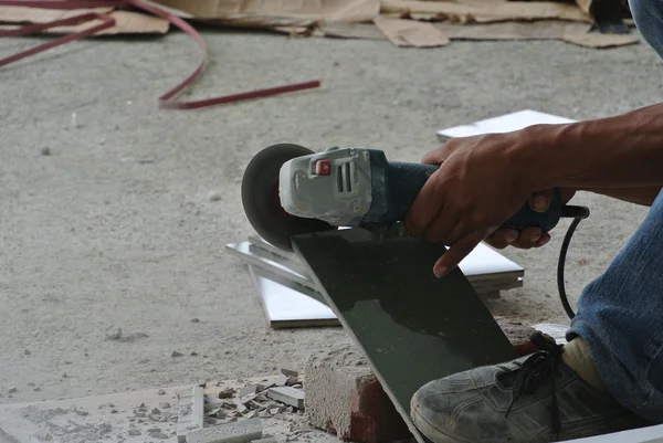 Construction workers using grinder to cut tiles — Stock Photo, Image