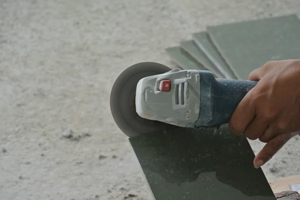 Construction workers using grinder to cut tiles — Stock Photo, Image