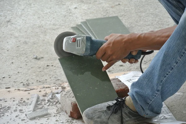 Construction workers using grinder to cut tiles — Stock Photo, Image