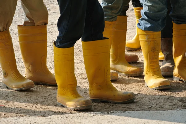 Trabajadores de la construcción en botas de seguridad amarillas — Foto de Stock