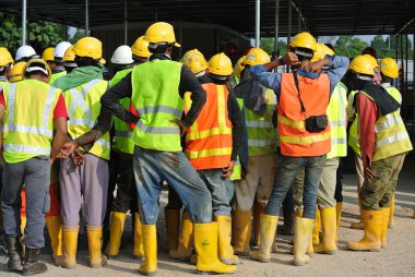 Group of construction workers assemble at the open space. clipart