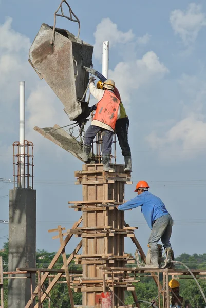 Group of construction workers casting column — Stock Photo, Image